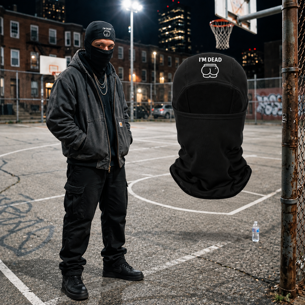 Original model wearing the black I'm Dead ski mask beside the matching floating mask on the nighttime basketball court