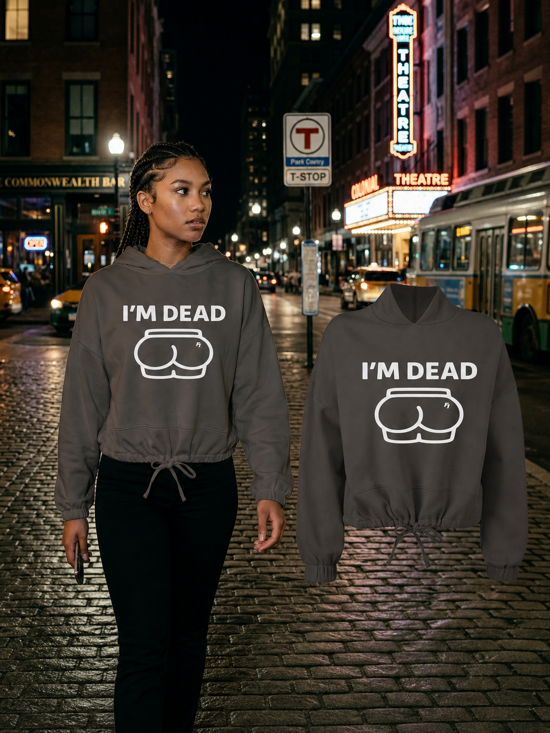 Female model wearing the Black Im Dead cropped hoodie beside the matching floating garment in Boston's Theatre District