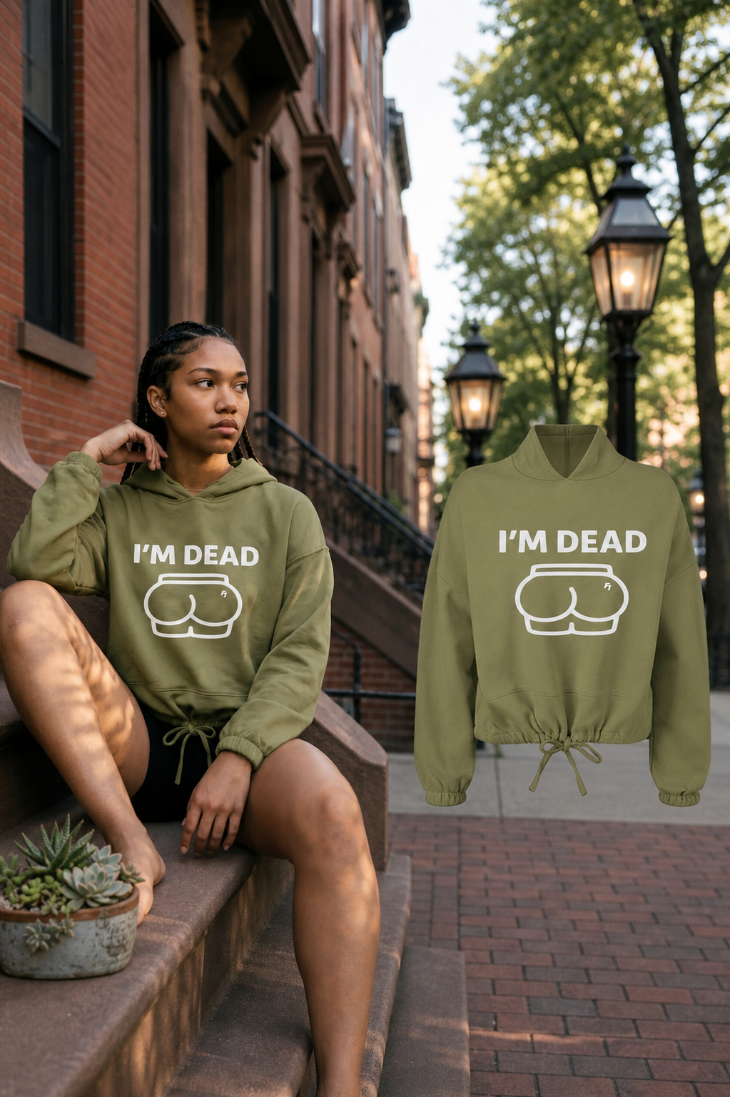 Female model wearing the Olive Im Dead cropped hoodie beside the matching floating garment on a Boston brownstone street