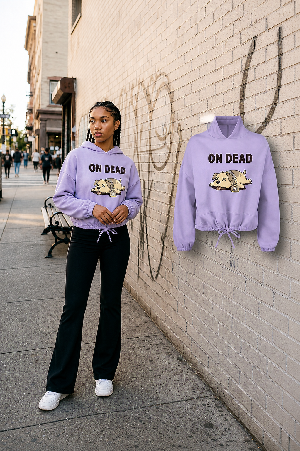 Female model in a distinct three-quarter pose wearing the Lilac On Dead cropped hoodie beside the fully visible matching floating garment on a Boston brick street