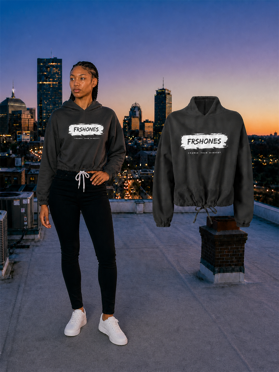 Full-body female model looking away from the matching Black Stroke of Genius cropped hoodie on a Boston rooftop